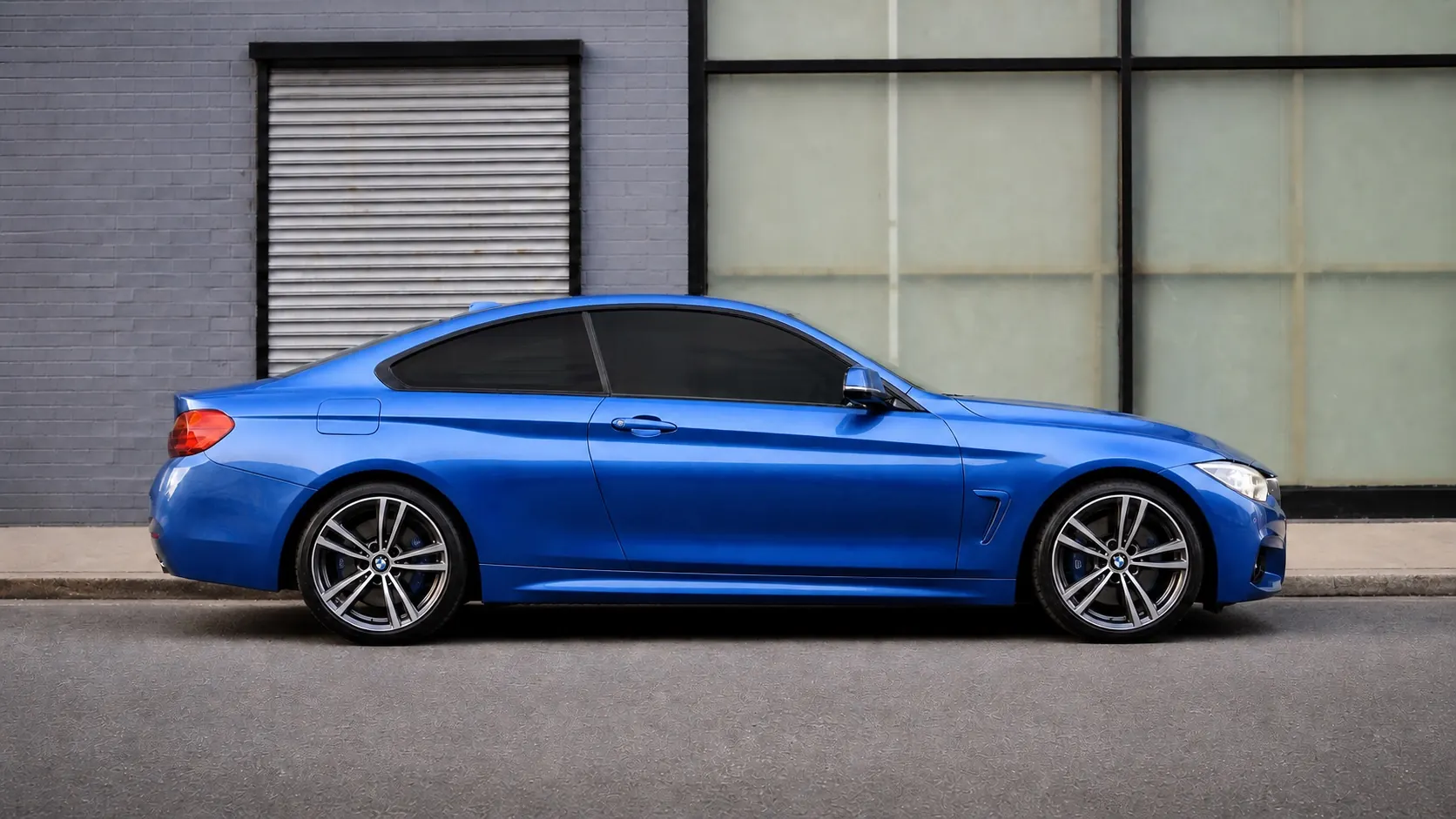 Blue coupe in side profile showing the darkest 5 percent tint visual